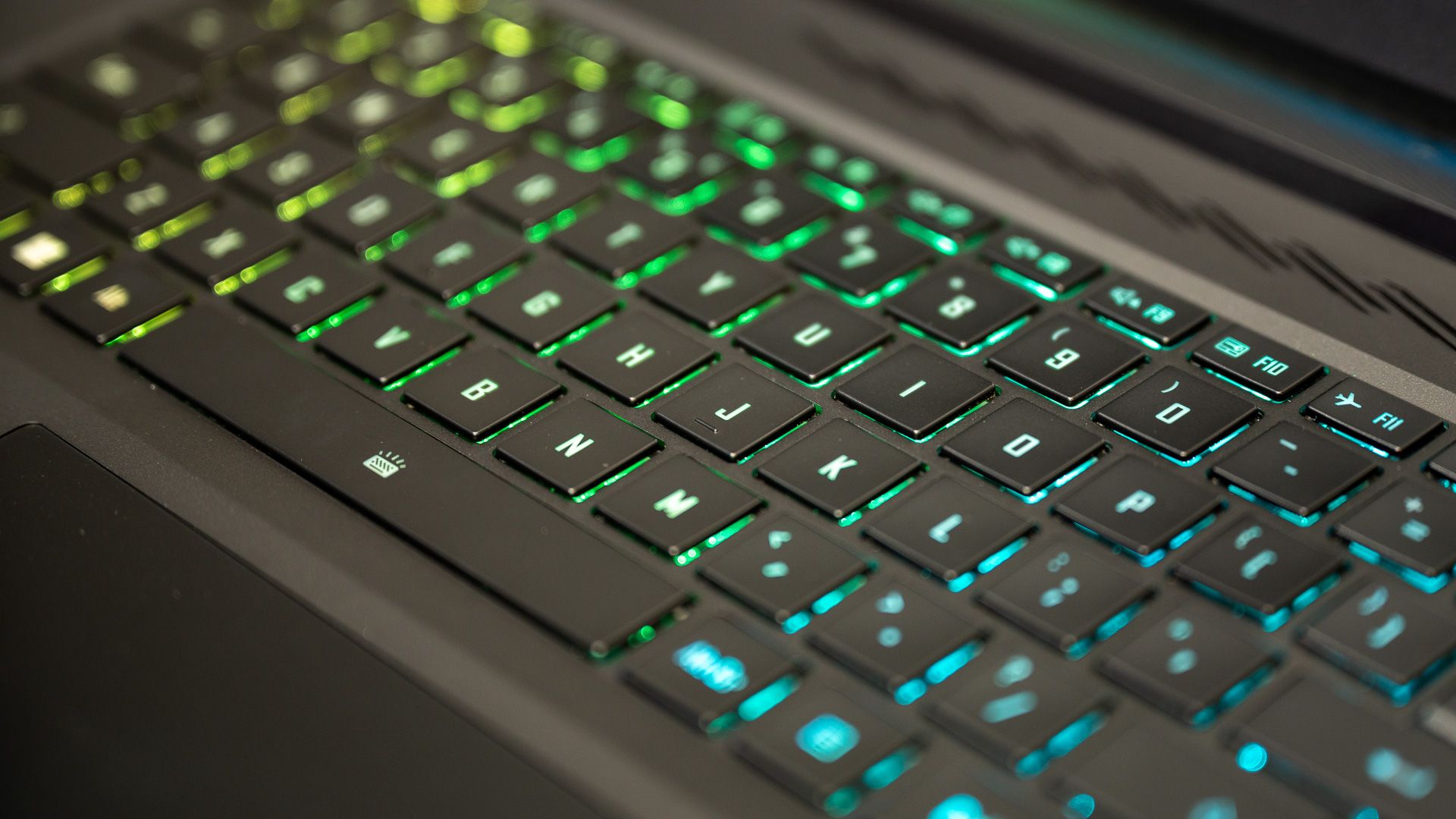Close-up de um teclado RGB de laptop para jogos verde e amarelo