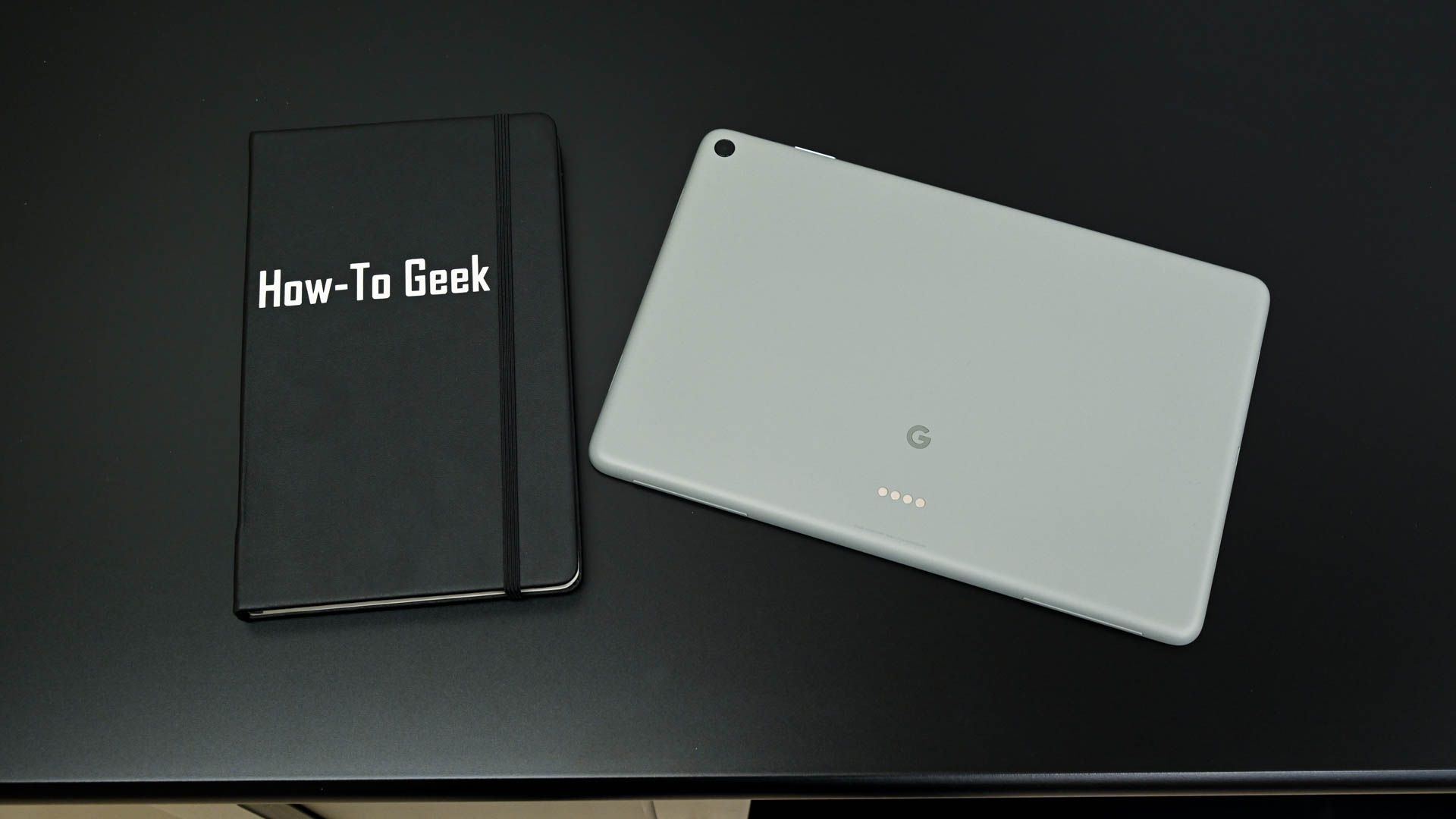 Parte traseira do Google Pixel Tablet ao lado de um notebook