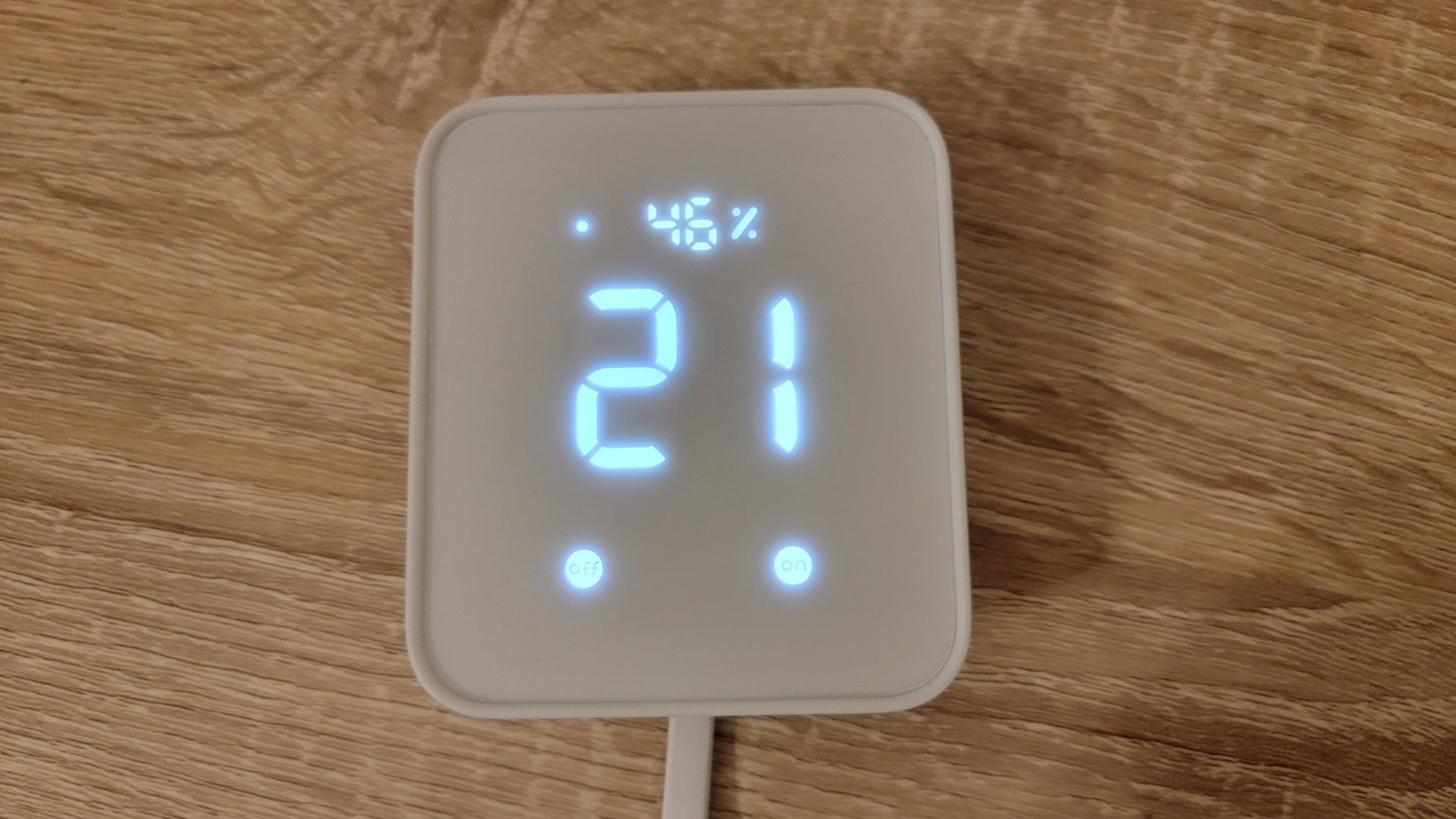 SwitchBot Hub 2 em mesa de madeira mostrando temperatura e umidade