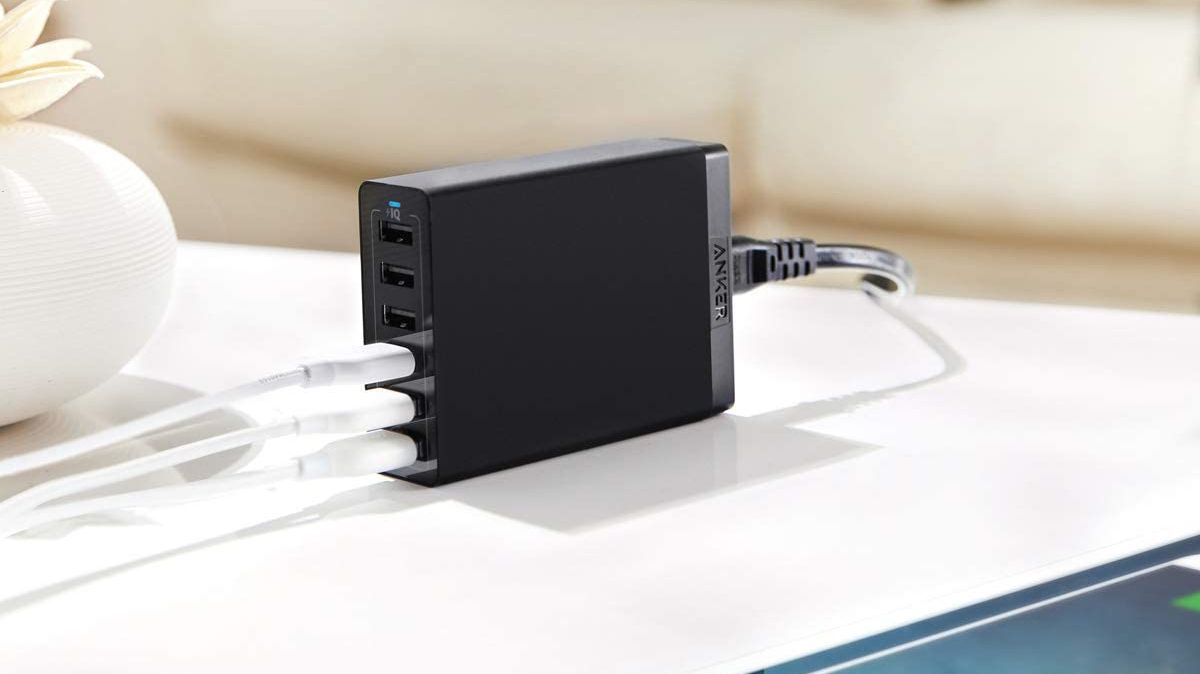 Carregador de parede USB Anker 60W de 6 portas sentado na mesa com três cabos conectados