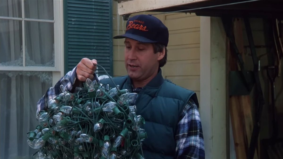 Um homem segura uma bola de luzes de Natal emaranhadas.