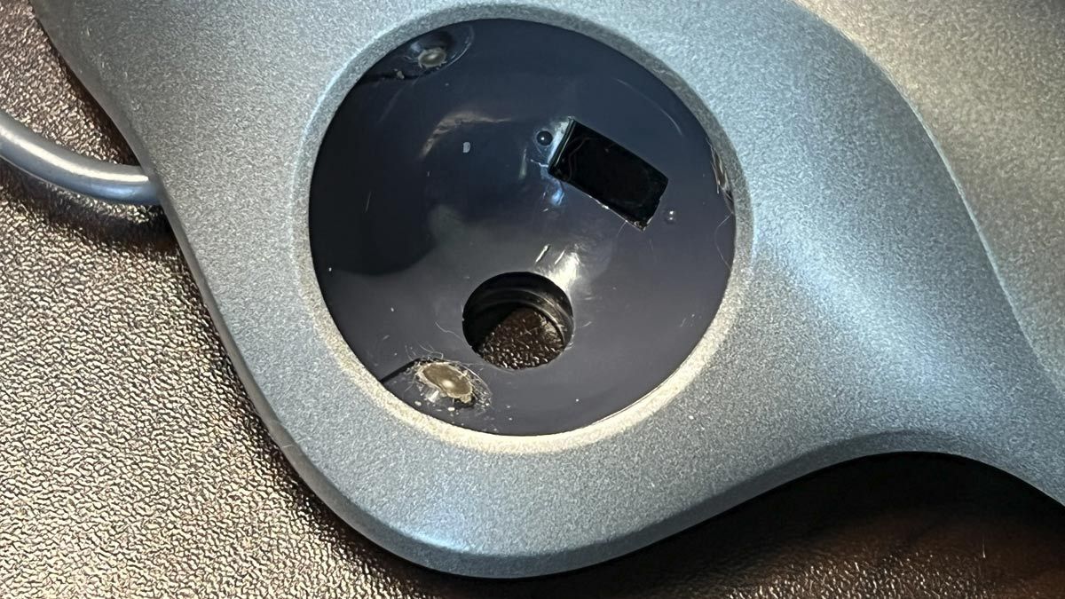 O interior de um mouse trackball, mostrando acúmulo de sujeira.