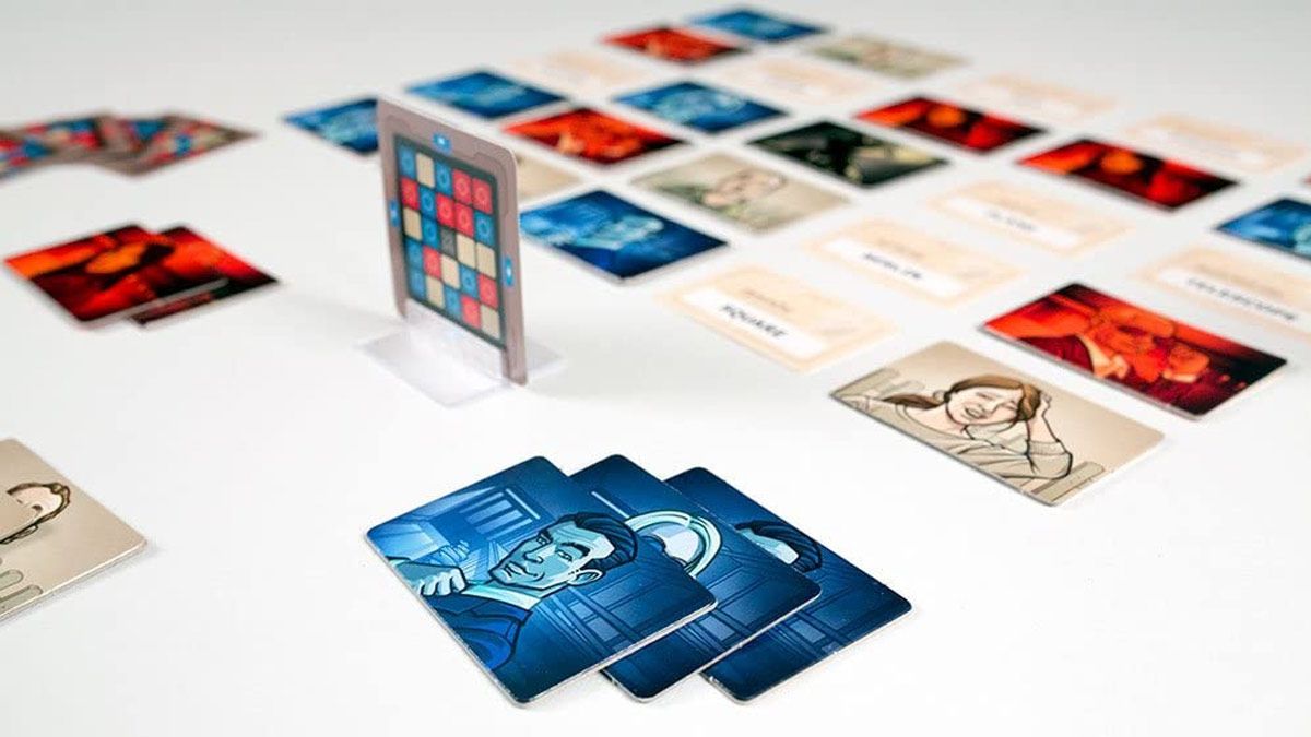 As fichas e cartas do jogo Codenames estão espalhadas sobre uma mesa.
