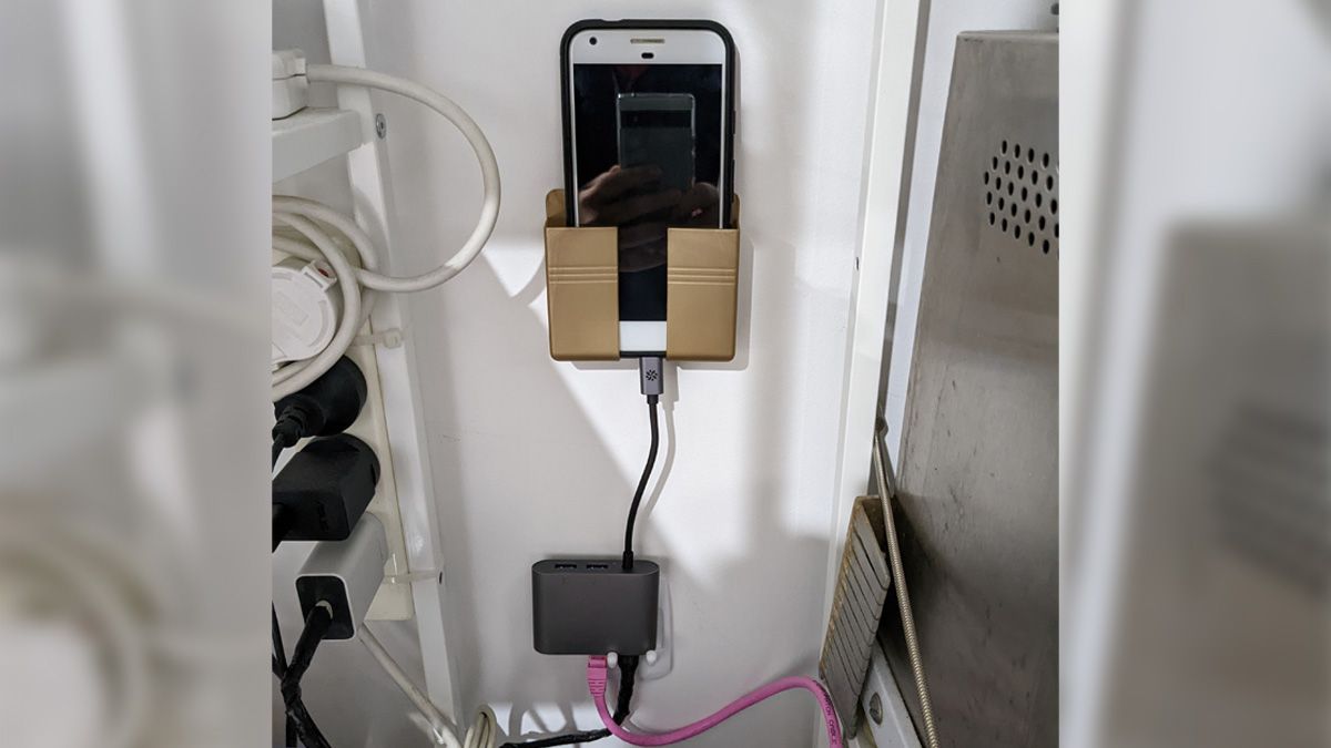 Foto de um smartphone Pixel em um armário, conectado a um hub USB