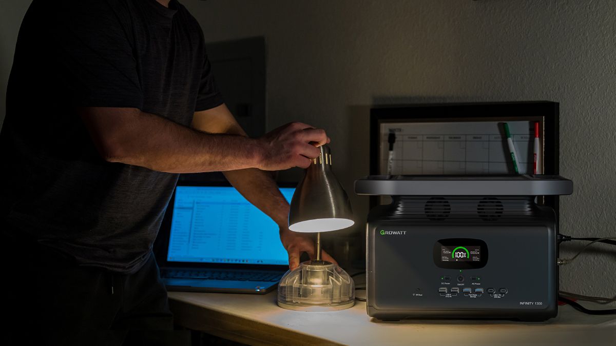 Homem acendendo uma luz conectada a uma bateria portátil Growatt INFINITY 1300