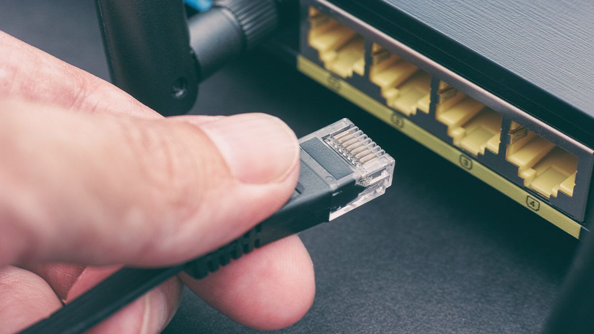 Alguém conectando o cabo Ethernet do adaptador MoCA ao roteador.