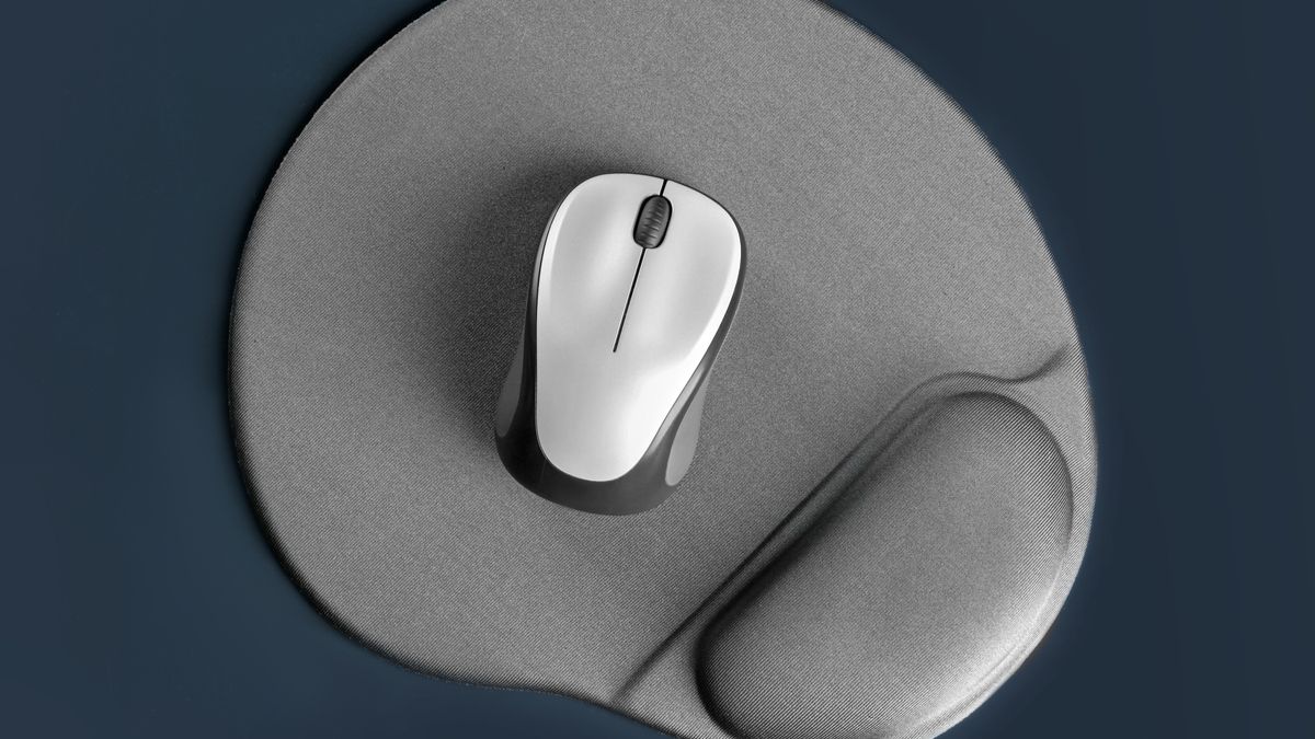Um mouse pad com pousa palmas e um mouse sem fio em cima.