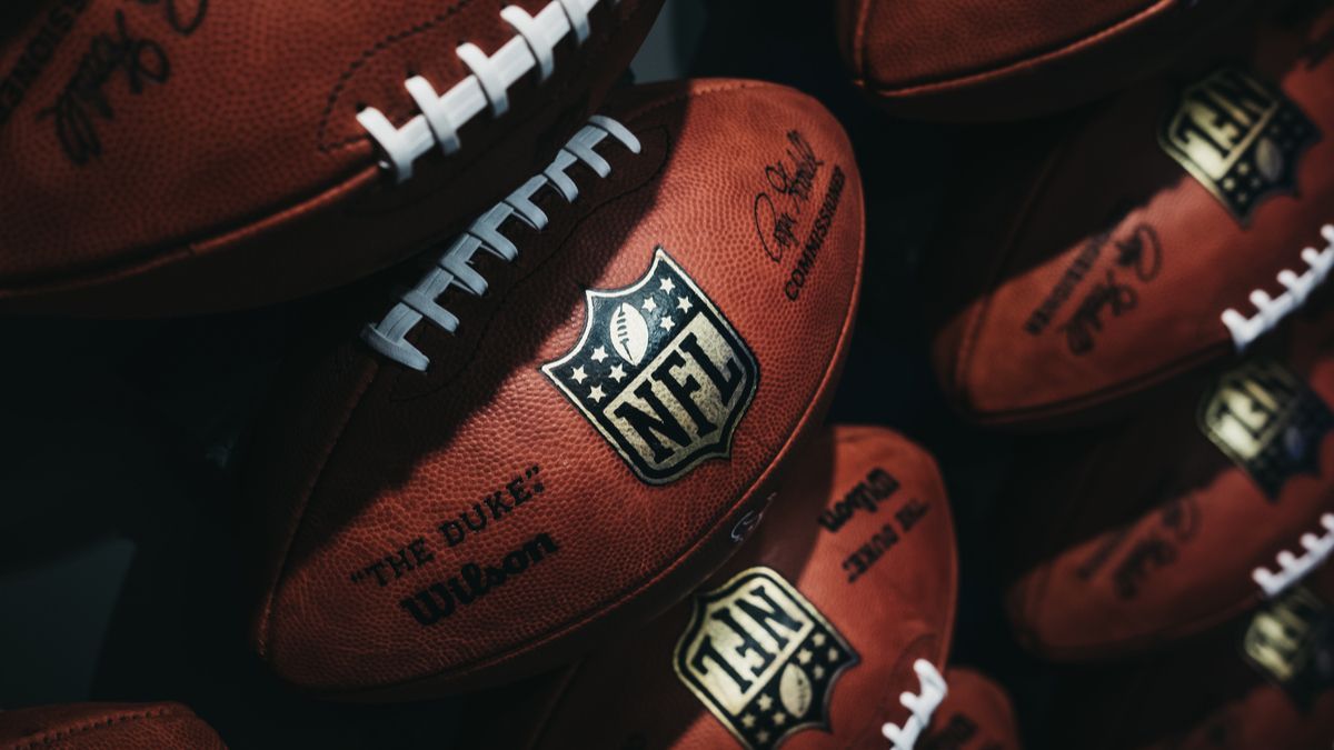 Bolas de futebol da NFL alinhadas contra a parede