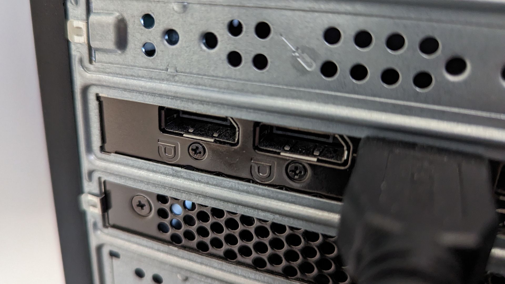 Close de duas portas do conector DisplayPort na parte traseira de uma torre de PC.