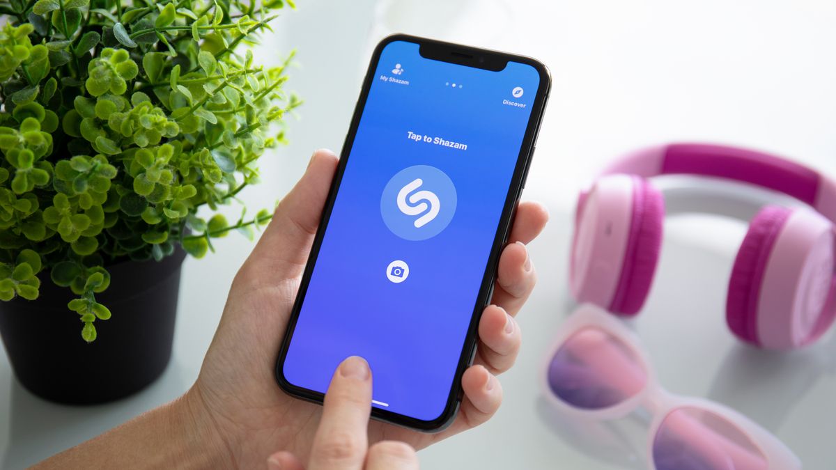 Pessoa identificando uma música usando o aplicativo Shazam em um iPhone