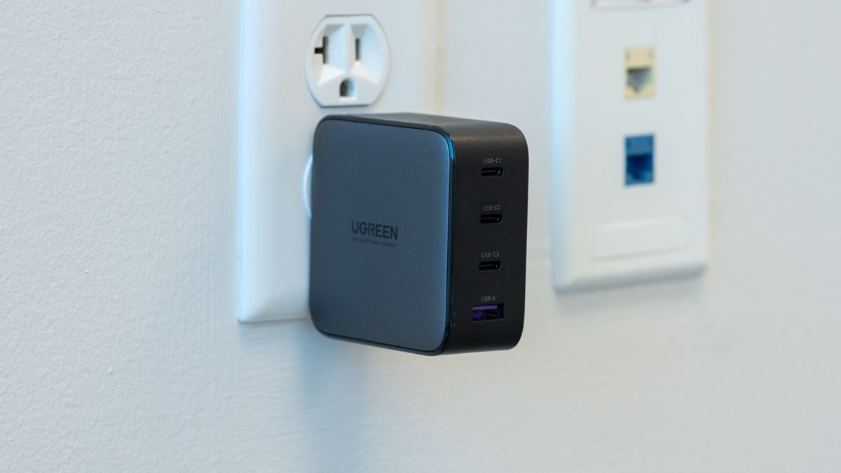 Carregador UGREEN Nexode 100W conectado à parede com a marca da empresa exibida