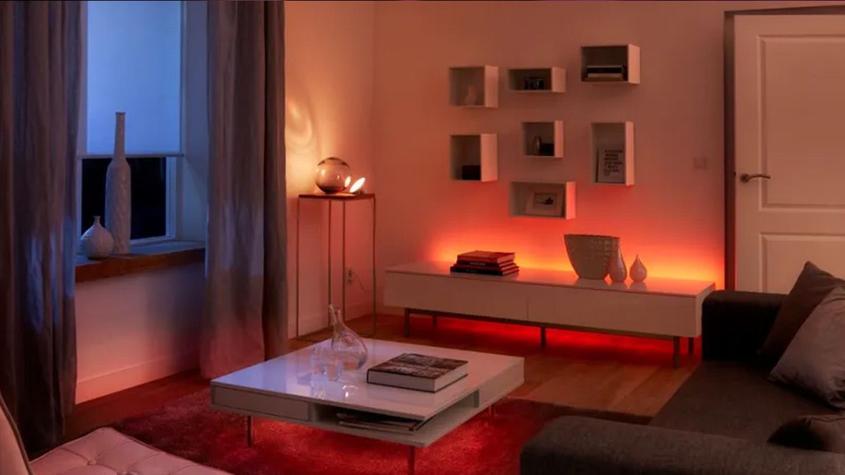 Uma sala de estar com luzes inteligentes Hue iluminando-a à noite.