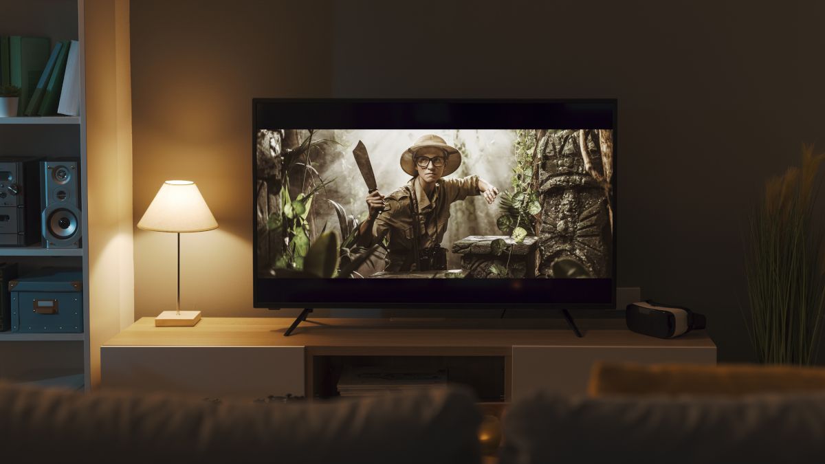 Uma TV na sala de estar com um filme de aventura em exibição.