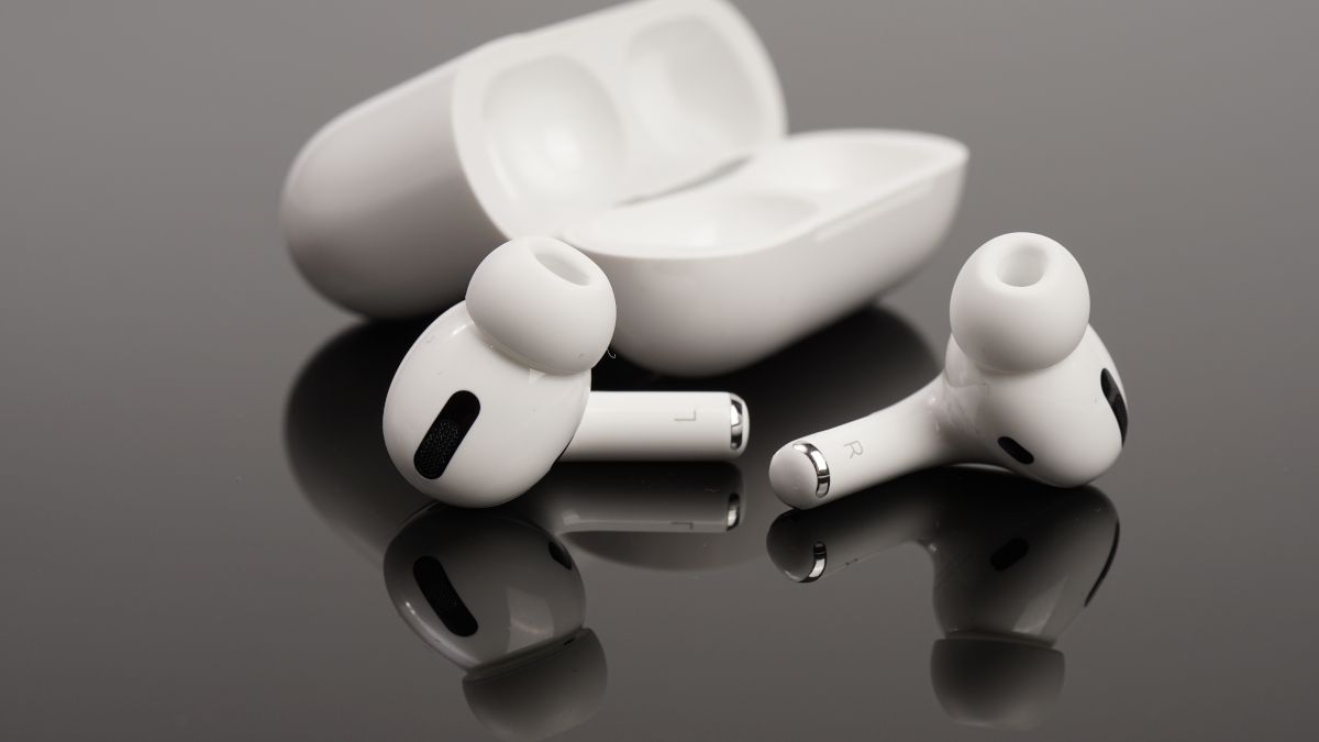 Apple Airpods e case em uma superfície reflexiva escura