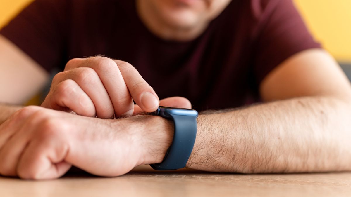 Homem pressionando botão em um Apple Watch.