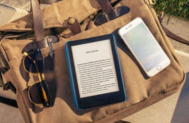 kindle em estojo em bolsa de lona com telefone e óculos de sol