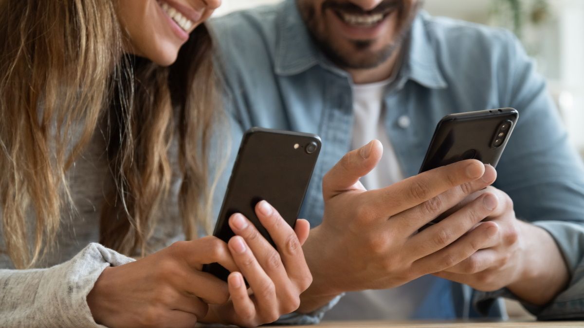 Um casal usando smartphones.