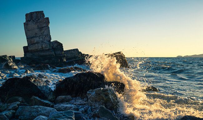 Ondas sendo lançadas contra as rochas do oceano.