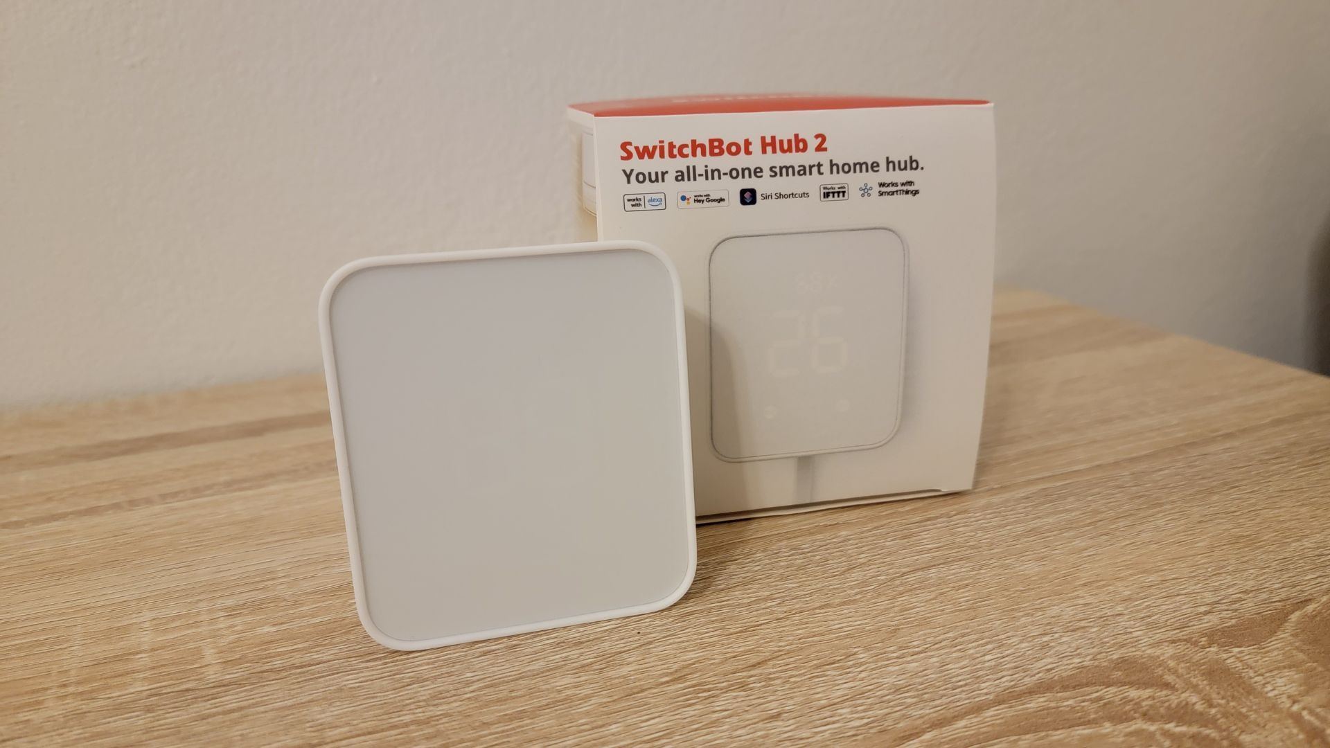 SwitchBot Hub 2 desligado ao lado da caixa do produto