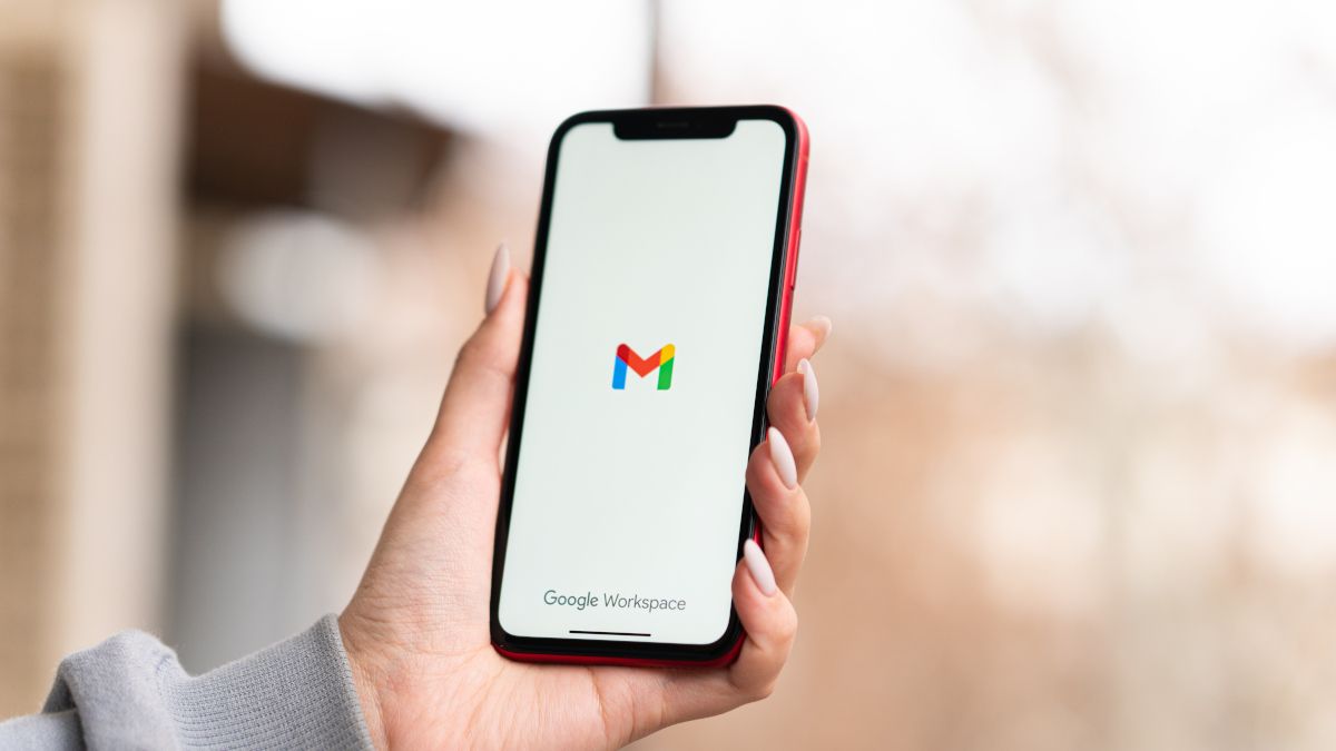 Mão de uma mulher segurando um iPhone com o logotipo do Gmail em exibição.