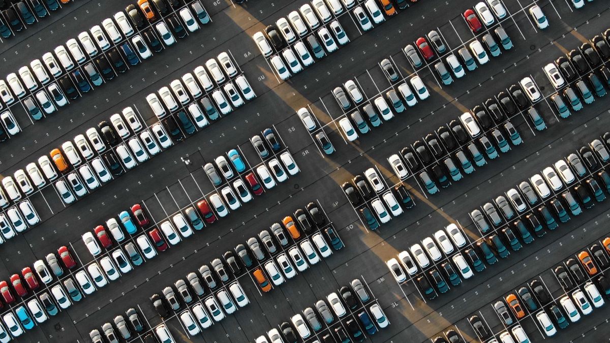 Uma vista aérea de centenas de veículos estacionados em um estacionamento