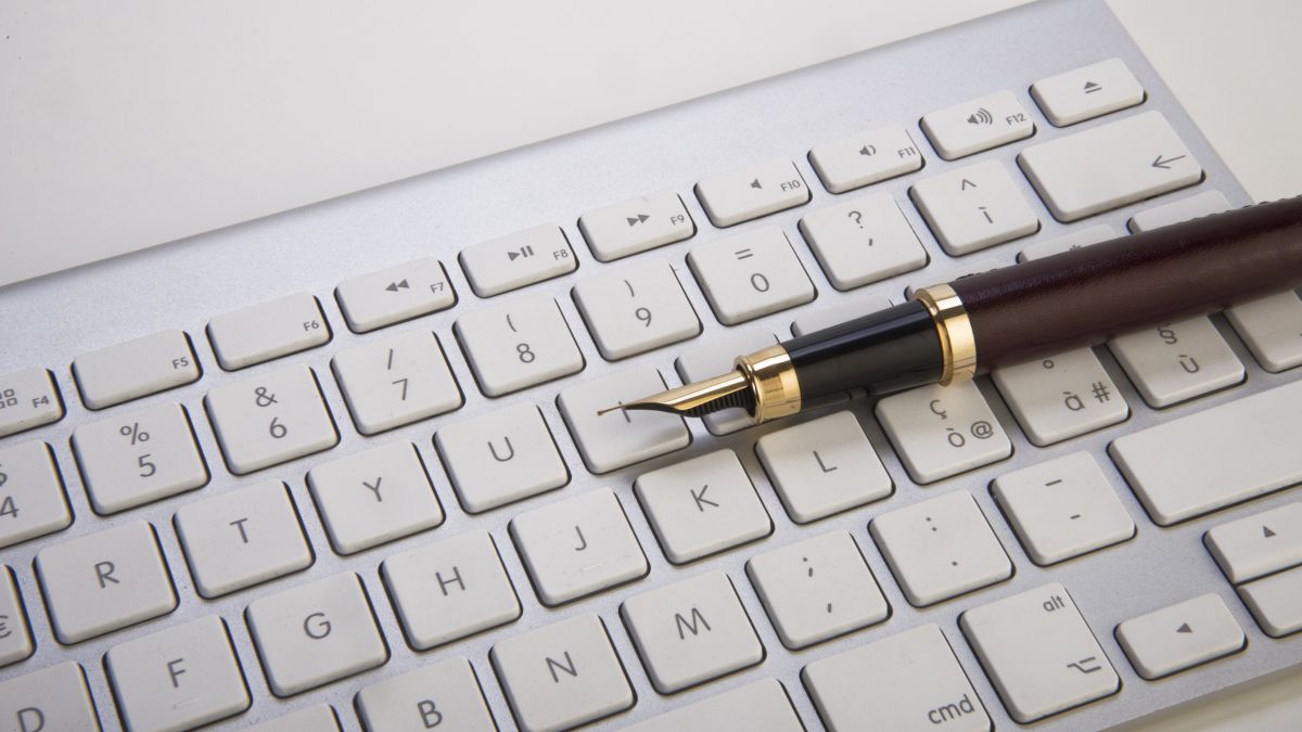Uma caneta-tinteiro em um teclado de computador.