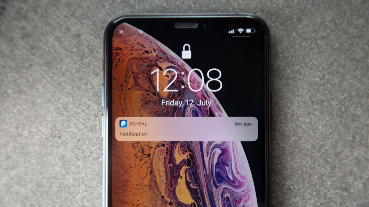 Tela de bloqueio de um iPhone com notificação do PayPal.