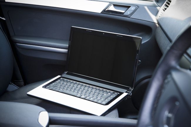 Um laptop no banco do passageiro do carro.