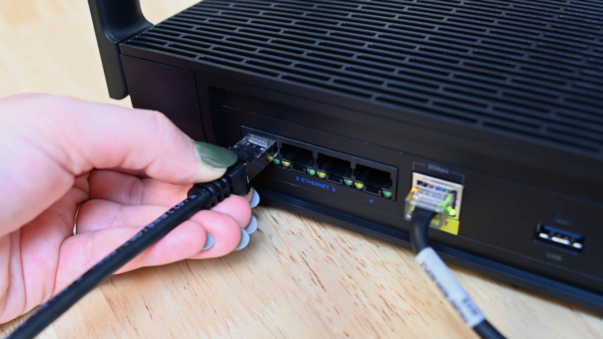 Pessoa conectando o cabo Ethernet Cable Matters em um roteador