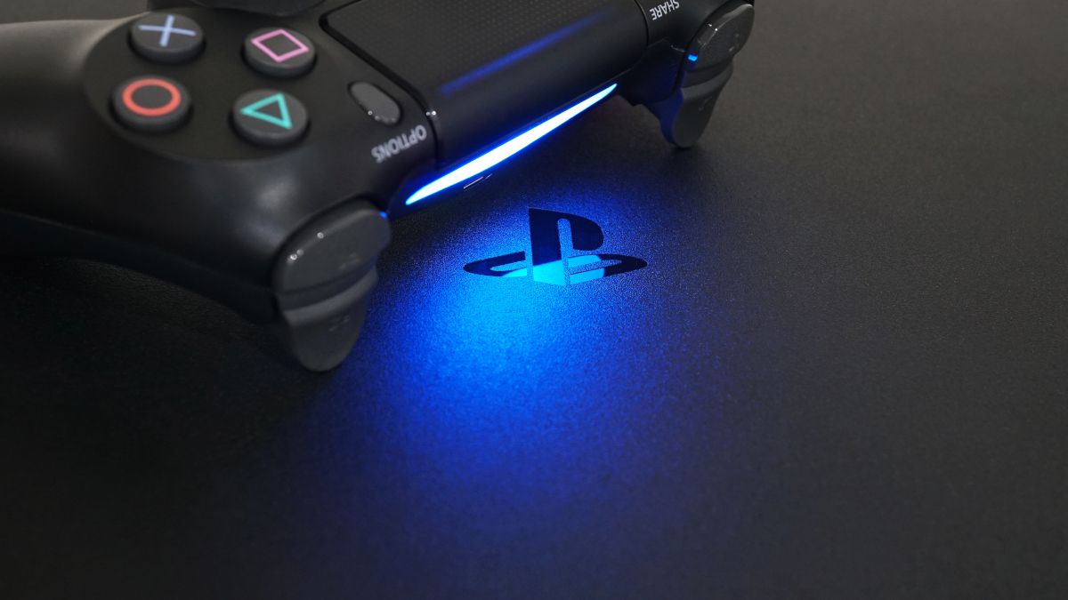 Logotipo do PlayStation em um PS4, em luz azul emitida por um controle