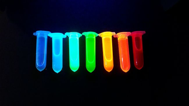 Tubos de plástico com pontos quânticos de nanocristais de perovskita, luminescentes com todas as cores do arco-íris sob radiação ultravioleta.