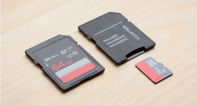 Cartão SD próximo a um cartão microSD e adaptador
