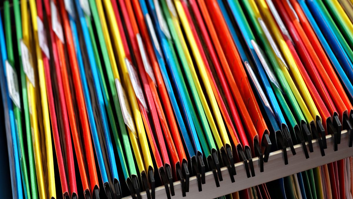 Pastas de arquivos coloridas em uma gaveta do armário.