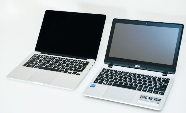 Um Apple MacBook Pro ao lado de um laptop Acer Aspire.