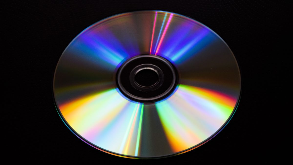 Um disco compacto de DVD isolado em um fundo preto.