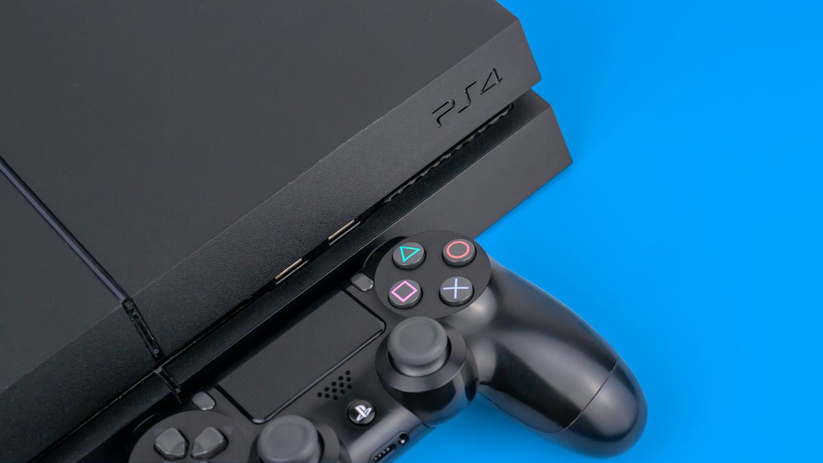 Um console Sony PS4 com um controlador DualShock próximo a ele em um fundo azul.