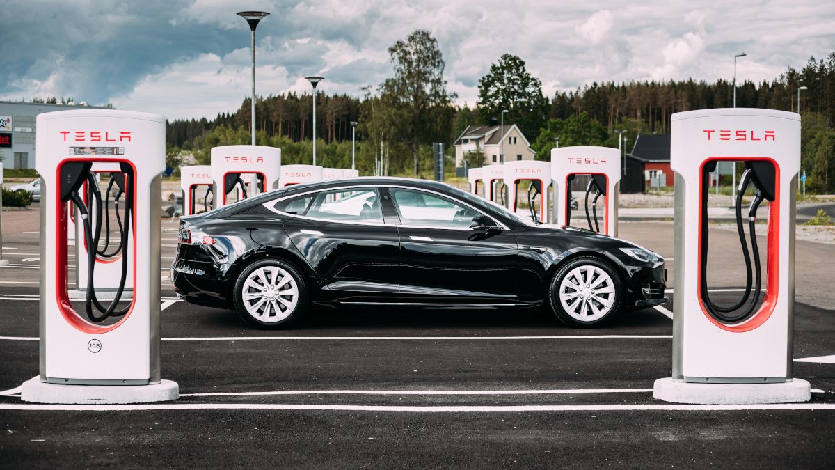 Um carro Tesla Model S 100d preto estacionado numa estação de carregamento.