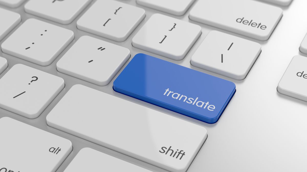 Um botão de tradução azul em um teclado de computador branco.