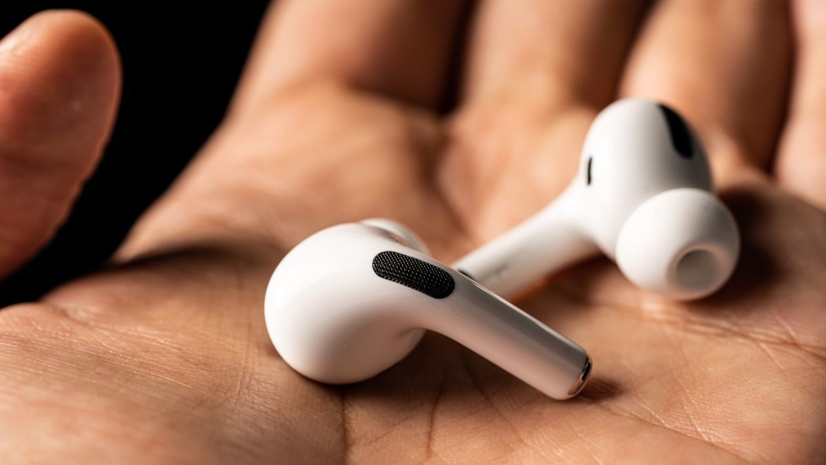 Um par de AirPods nas mãos de uma pessoa