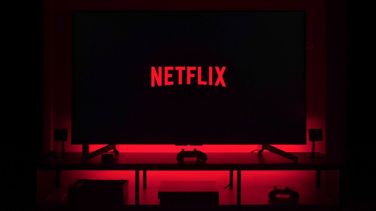 O logotipo da Netflix em uma TV em um quarto escuro.