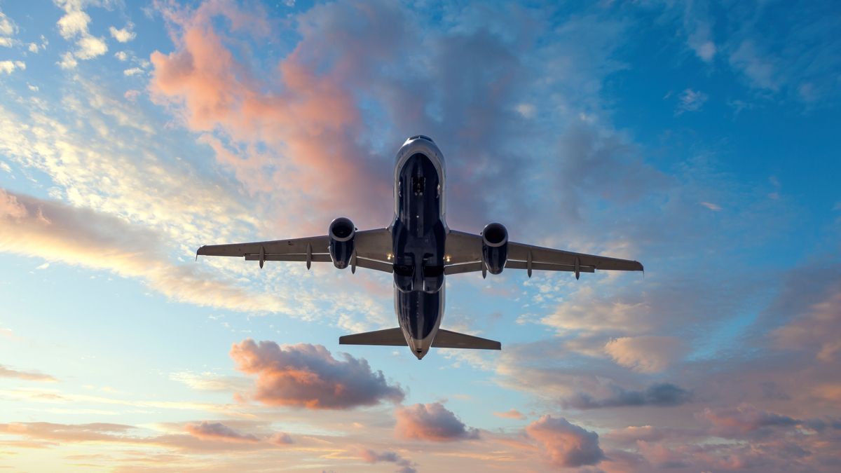 Avião a jato após partir do aeroporto ao pôr do sol