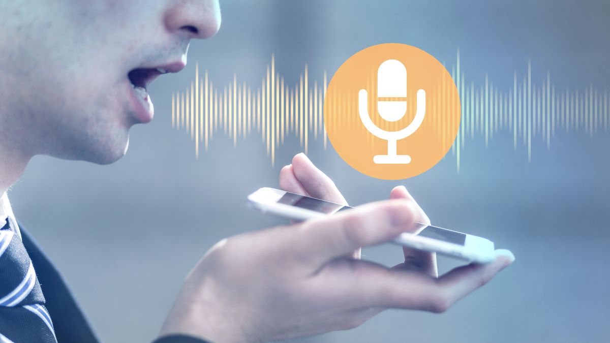 Homem falando com um smartphone com ondas sonoras saindo da boca e um ícone de microfone acima do telefone.