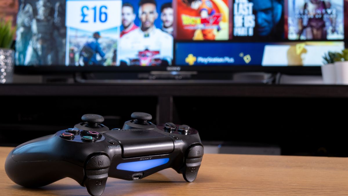 Um controlador Sony Dualshock 4 em frente a uma TV mostrando a PlayStation Store.