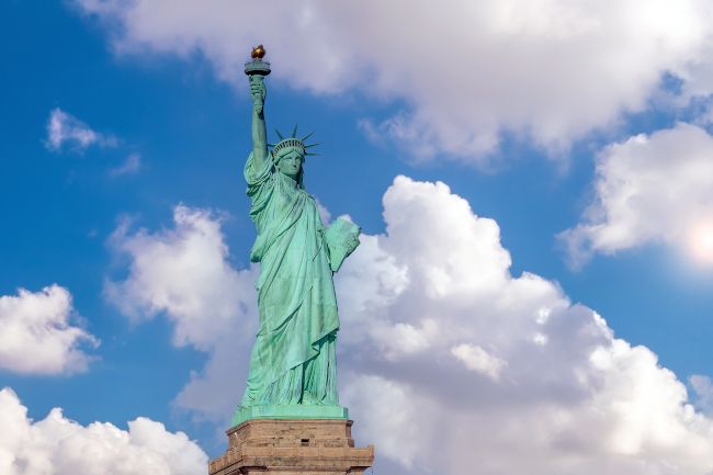 A Estátua da Liberdade em Manhattan, Nova York, com nuvens ao fundo.