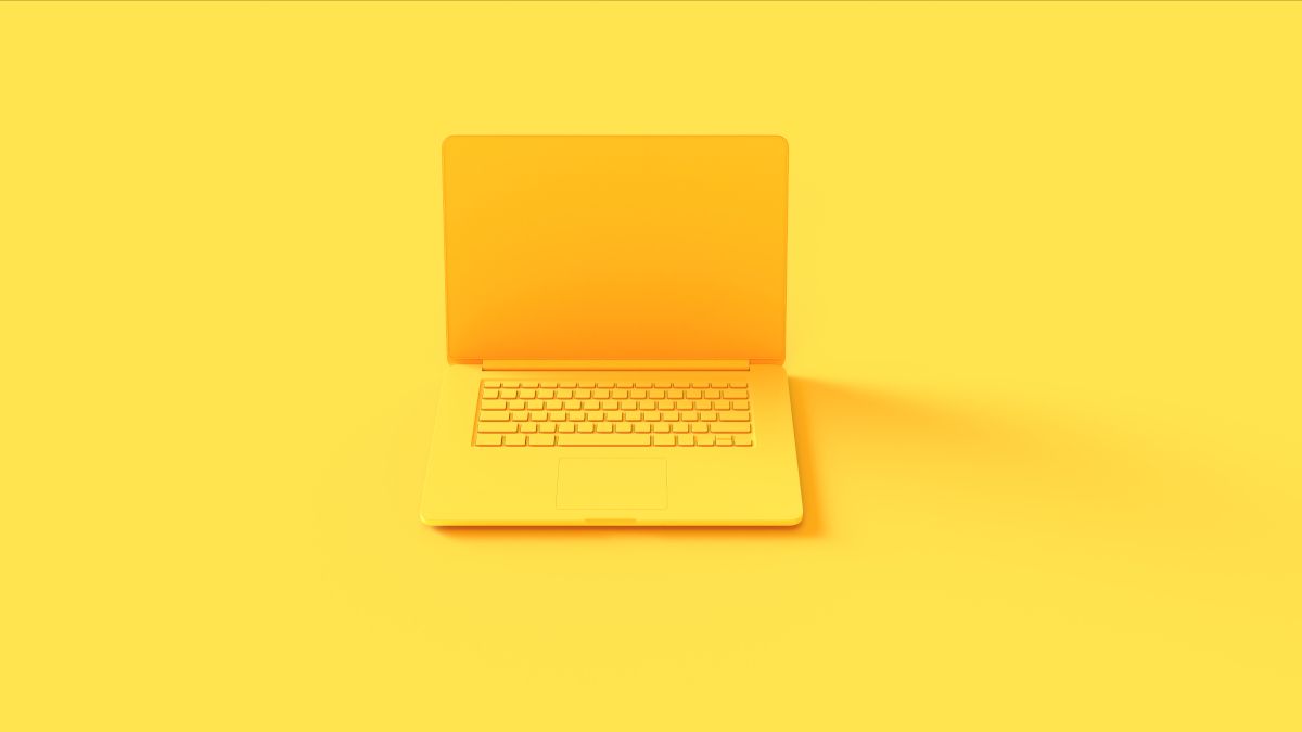 Um laptop amarelo sobre um fundo amarelo.